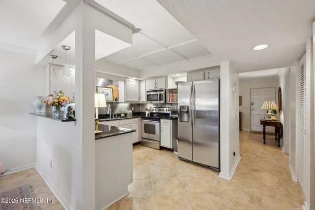 a kitchen with refrigerator and chairs