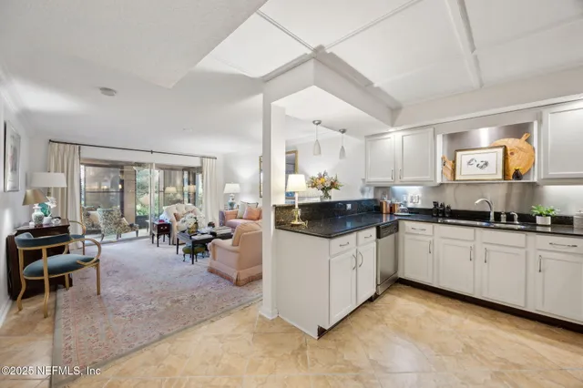 a kitchen with sink cabinets and living room view