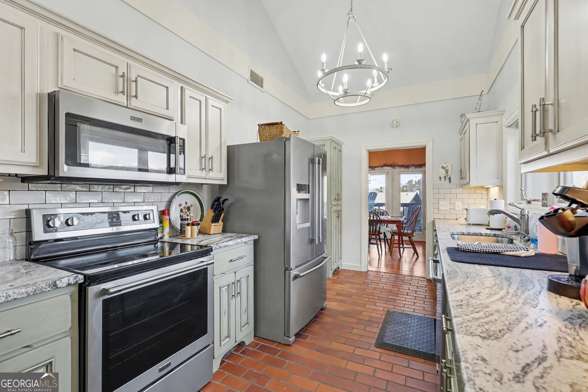 62 Sunvalley Circle, Unit 7006 Dillard, GA 30537 - Photo 23 of 55 a kitchen with stainless steel appliances granite countertop a stove top oven a refrigerator and a dining table with wooden floor