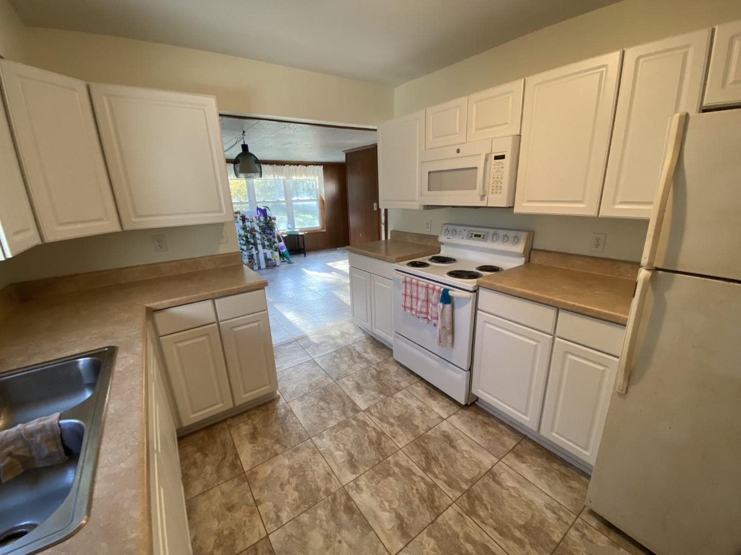 10361 Becker Road Savanna, IL 61074 - Photo 12 of 23 a kitchen with white cabinets and white appliances