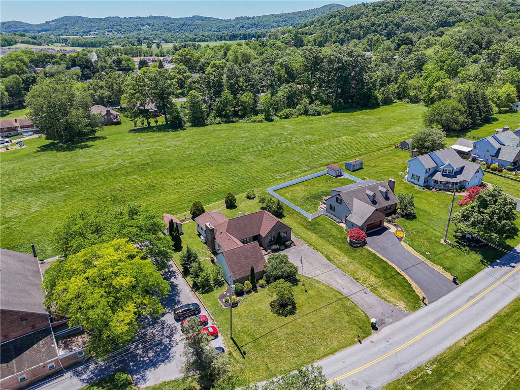 652 Old State Road Oley, PA 19547 - Photo 5 of 54 An aerial perspective reveals a serene residential landscape nestled against a backdrop of rolling, tree-covered hills.