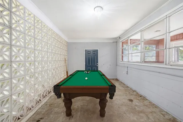 a room with pool table and windows
