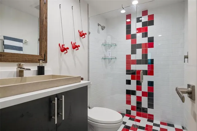 a bathroom with a sink toilet vanity and shower