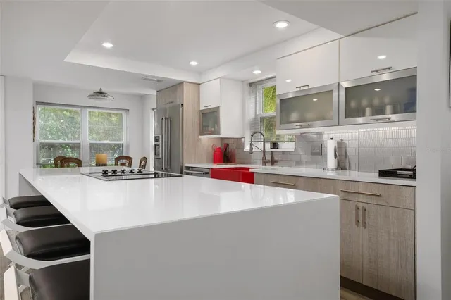 a large kitchen with stainless steel appliances a large counter top a stove and a sink