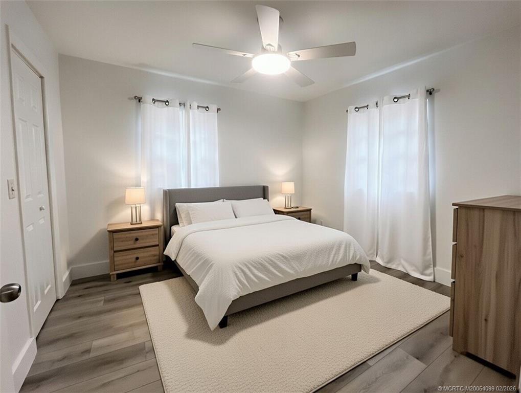 808 Southwest 33rd Street Palm City, FL 34990 - Photo 5 of 13 a bedroom with a bed and a chandelier
