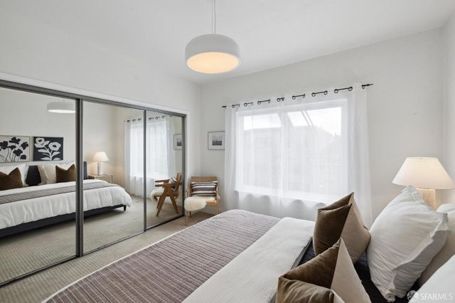 a bedroom with furniture and a large window