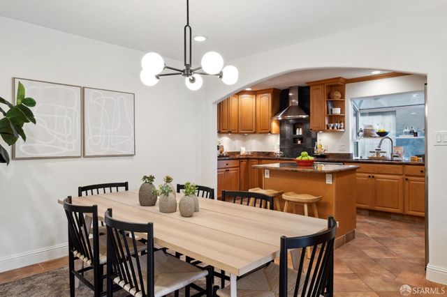 a view of a dining room with furniture a chandelier and wooden floor
