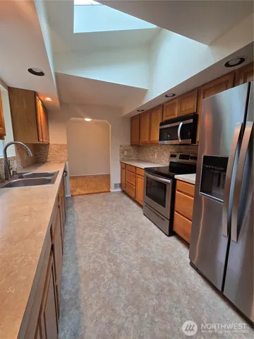 a kitchen with stainless steel appliances granite countertop a sink and a stove