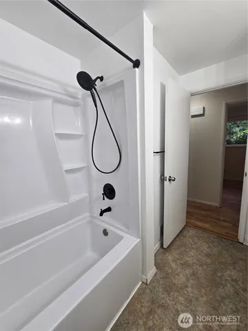 a bathroom with a bath tub a glass door shower and a sink