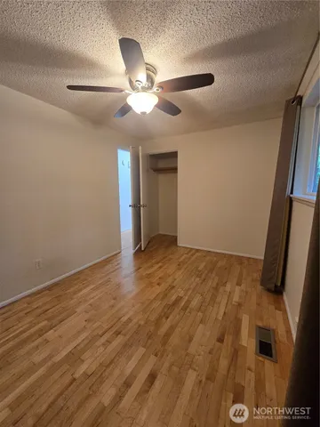 a view of an empty room and chandelier fan