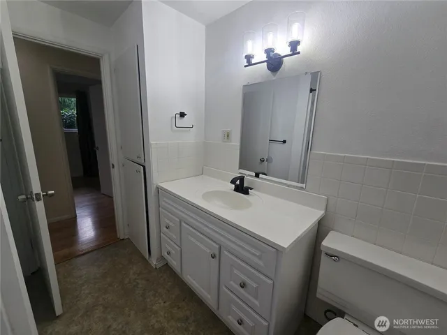 a bathroom with a sink a toilet and mirror