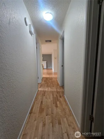 a view of a hallway with wooden floor