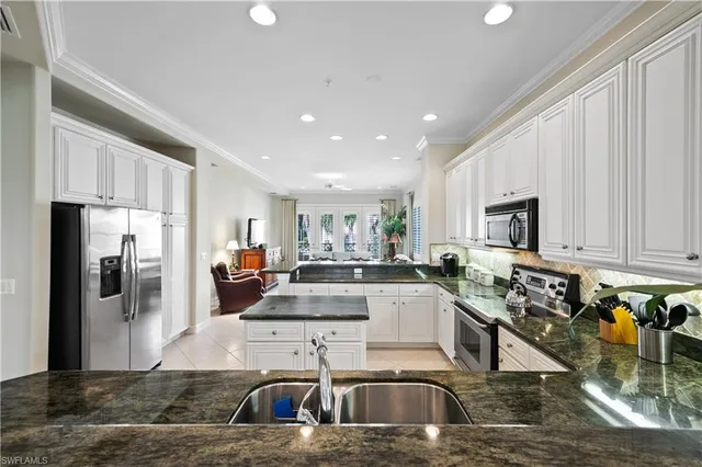 a kitchen with stainless steel appliances granite countertop a sink a stove and a refrigerator