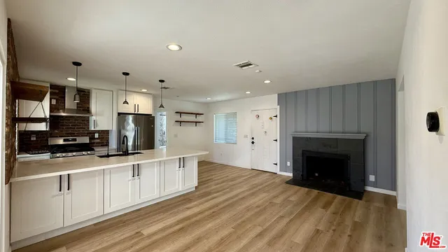 a large kitchen with stainless steel appliances granite countertop a stove and a sink with cabinets