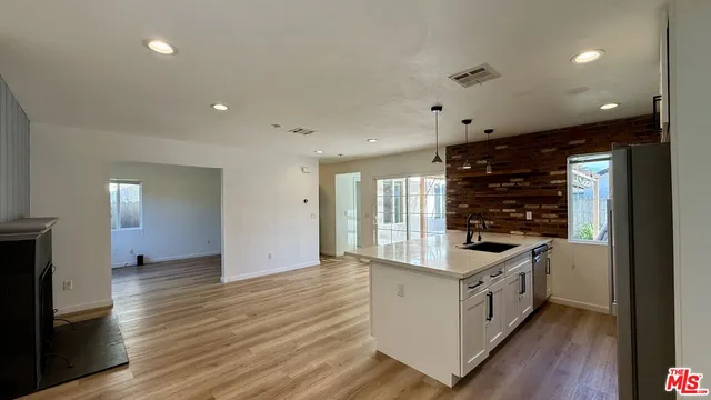 a kitchen with stainless steel appliances a stove and wooden floor