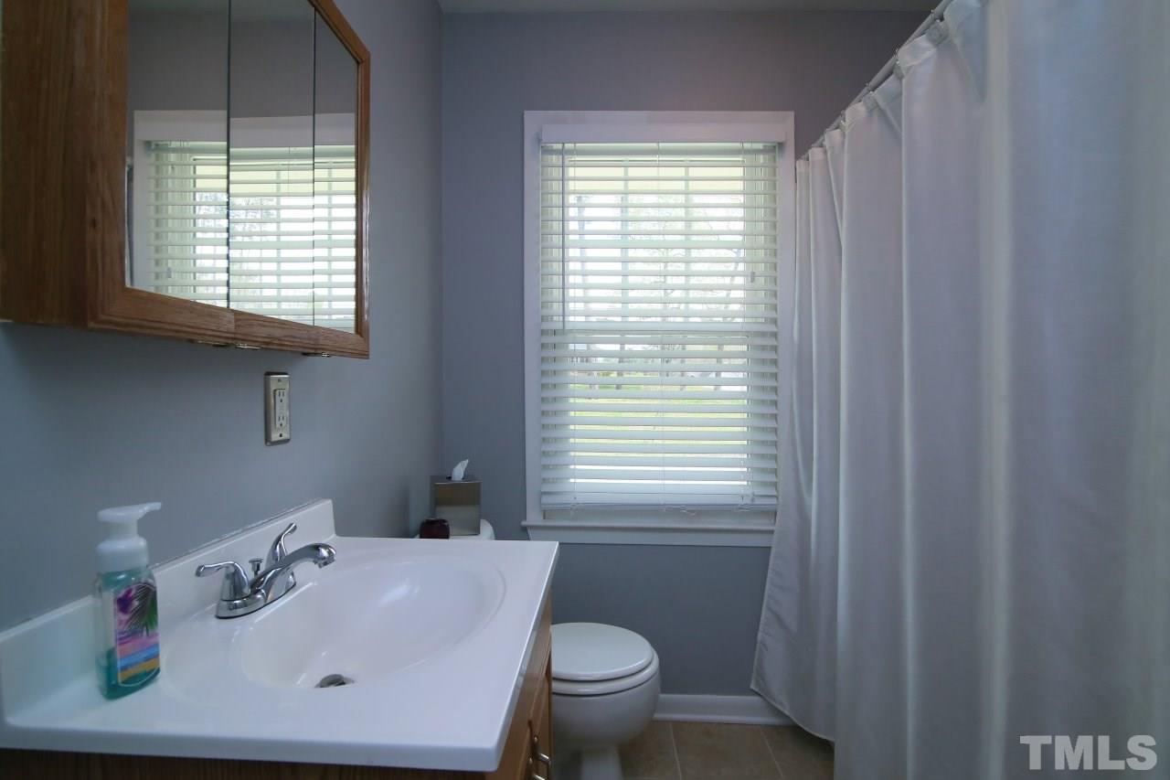 1501 Westchester Road Raleigh, NC 27610 - Photo 10 of 25 a bathroom with a sink a toilet and a window