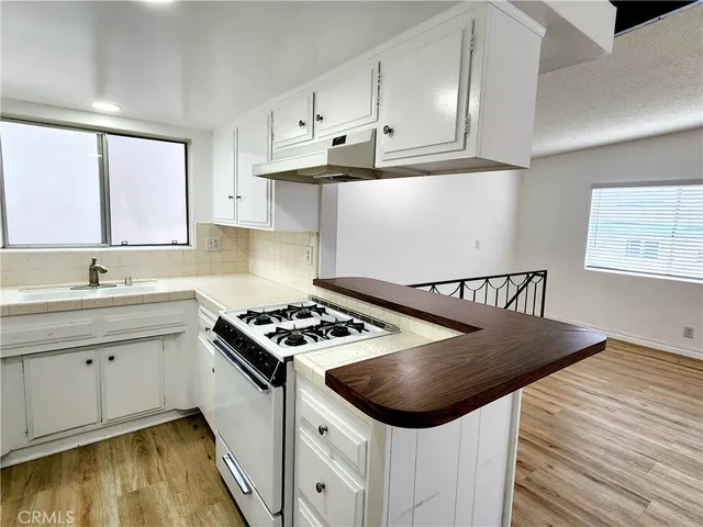 a kitchen with cabinets appliances a sink and a window