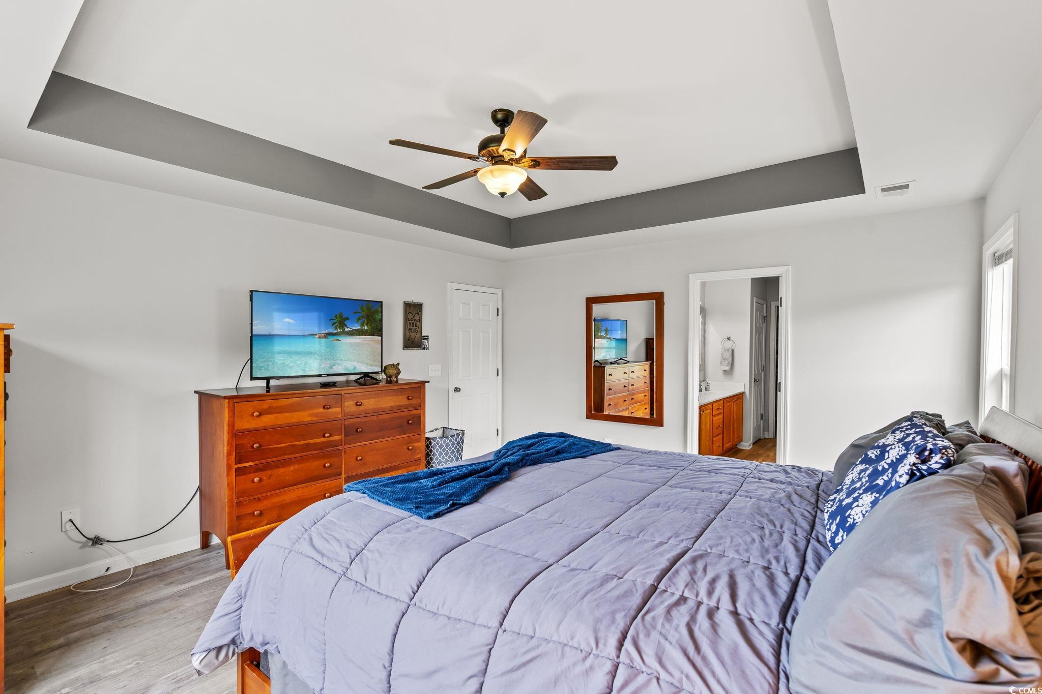 232 Marbella Drive Murrells Inlet, SC 29576 - Photo 14 of 40 Bedroom with a tray ceiling, light wood-style floo