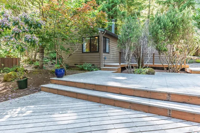 a backyard of a house with trees and outdoor seating