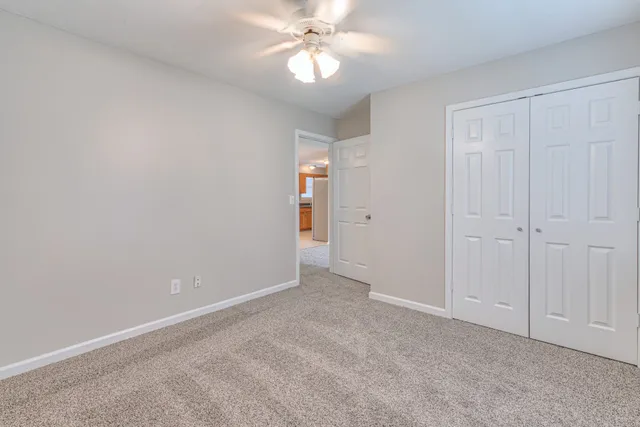 a view of an empty room and chandelier fan