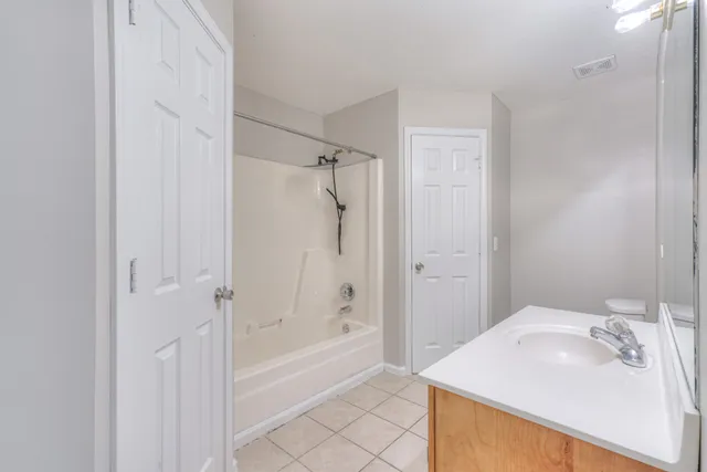 a bathroom with a bathtub shower sink and vanity