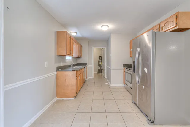 a kitchen with stainless steel appliances granite countertop a refrigerator and a stove