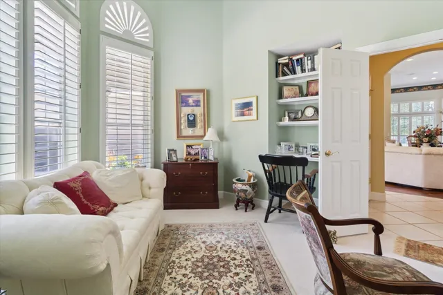 a living room with patio chairs and a floor to ceiling window