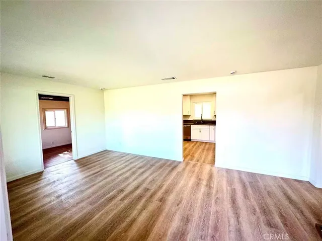 a view of a room with wooden floor and a ceiling fan