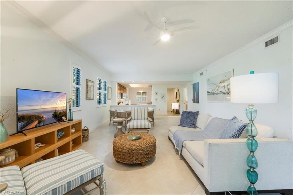 965 Sandpiper Street, Unit J107 Naples, FL 34102 - Photo 7 of 29 a living room with furniture and a flat screen tv