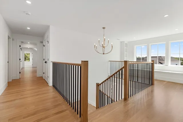a view of a hallway with wooden floor and windows