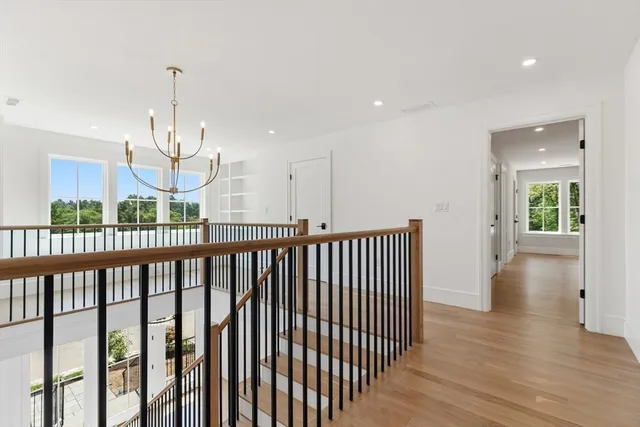 a view of a hallway with wooden floor and windows