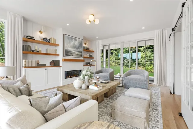 a living room with furniture fireplace and a large window