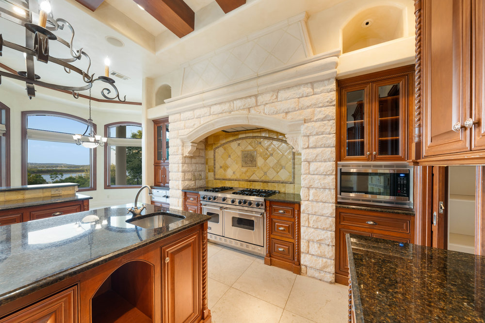 217 Bella Riva Drive Austin, TX 78734 - Photo 16 of 36 a kitchen with stainless steel appliances granite countertop a stove and a sink