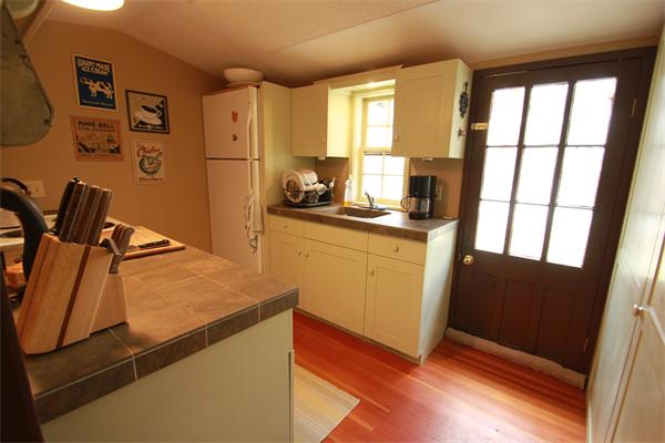 74 Ranney Corner Road Ashfield, MA 01330 - Photo 7 of 24 a kitchen with granite countertop a refrigerator a sink a stove and white cabinets with wooden floor