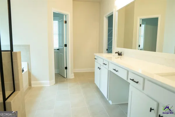 a spacious bathroom with a mirror sink and shower
