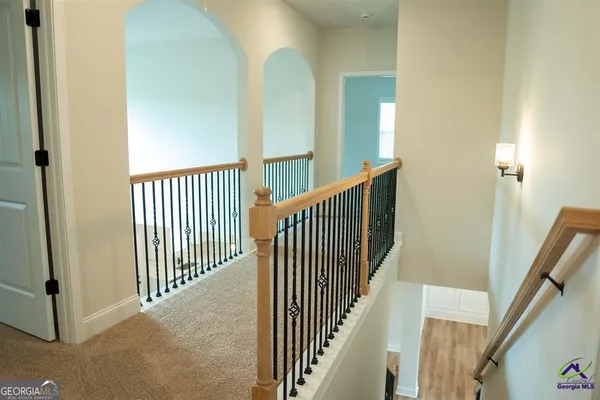 a view of a hallway with wooden floor and stairs