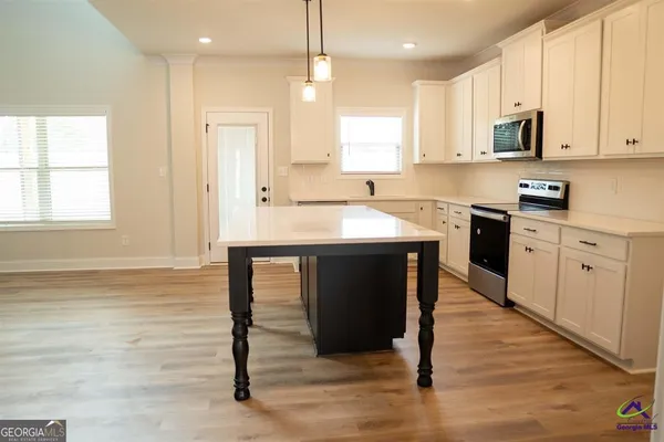 a view of a room with wooden floor staircase and a kitchen