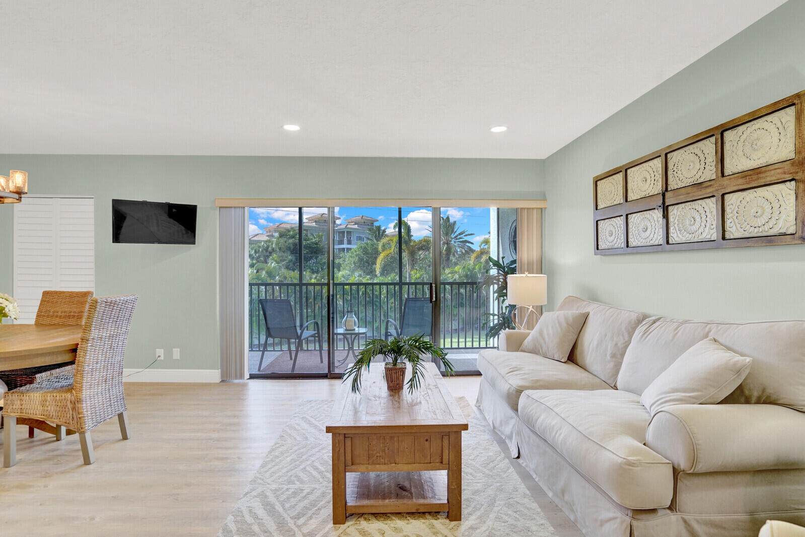 1605 Highway 1, Unit 202V5 Jupiter, FL 33477 - Photo 4 of 26 a living room with furniture floor to ceiling window and a flat screen tv