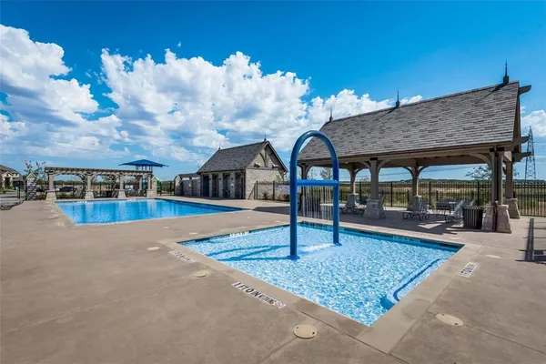 a swimming pool view with a seating space