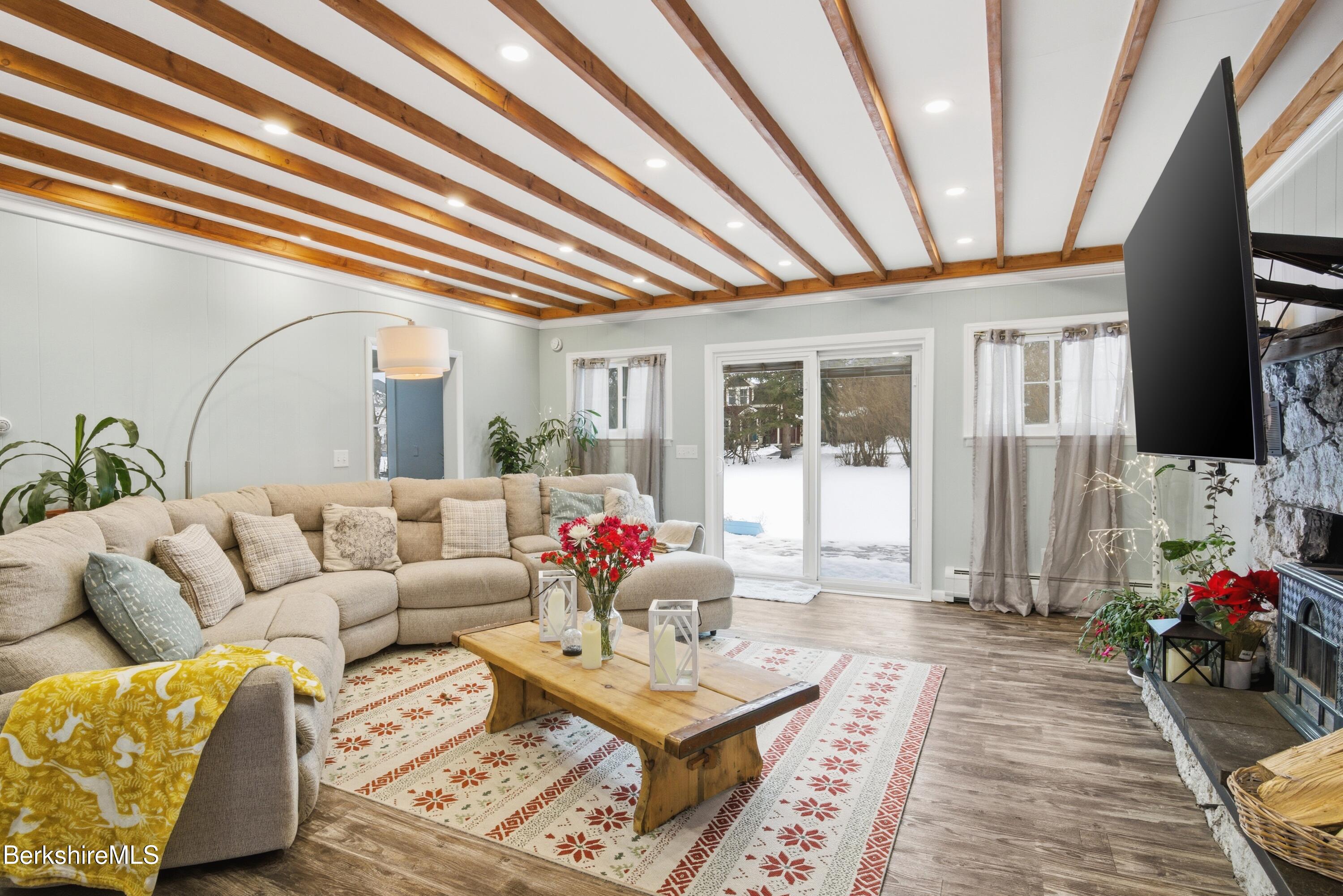 6 Vine Street Pittsfield, MA 01201 - Photo 6 of 37 a living room with furniture a flat screen tv and a floor to ceiling window