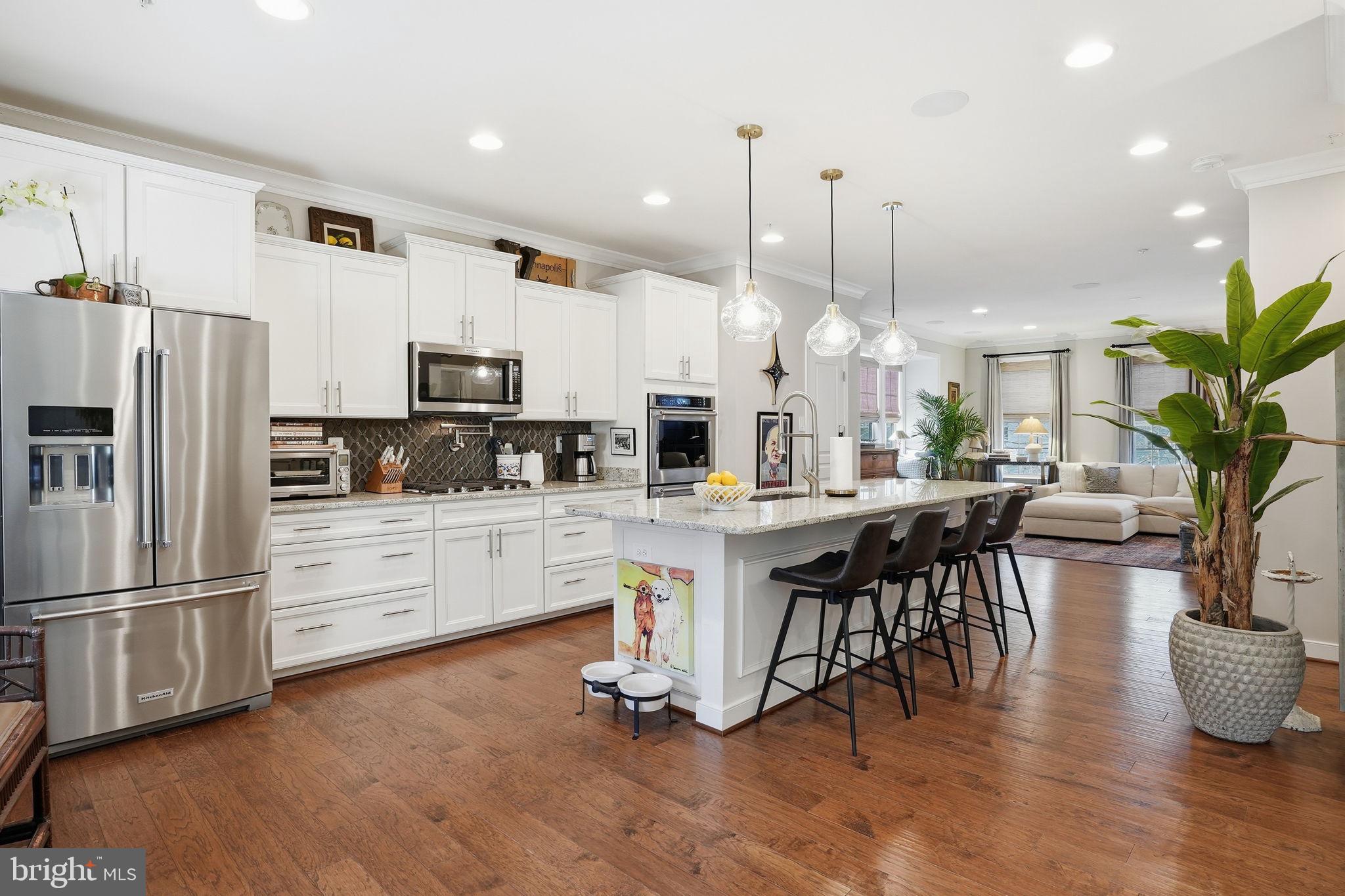 126 Admirals Ridge Drive Arnold, MD 21012 - Photo 3 of 58 a kitchen with stainless steel appliances a dining table chairs stove and white cabinets