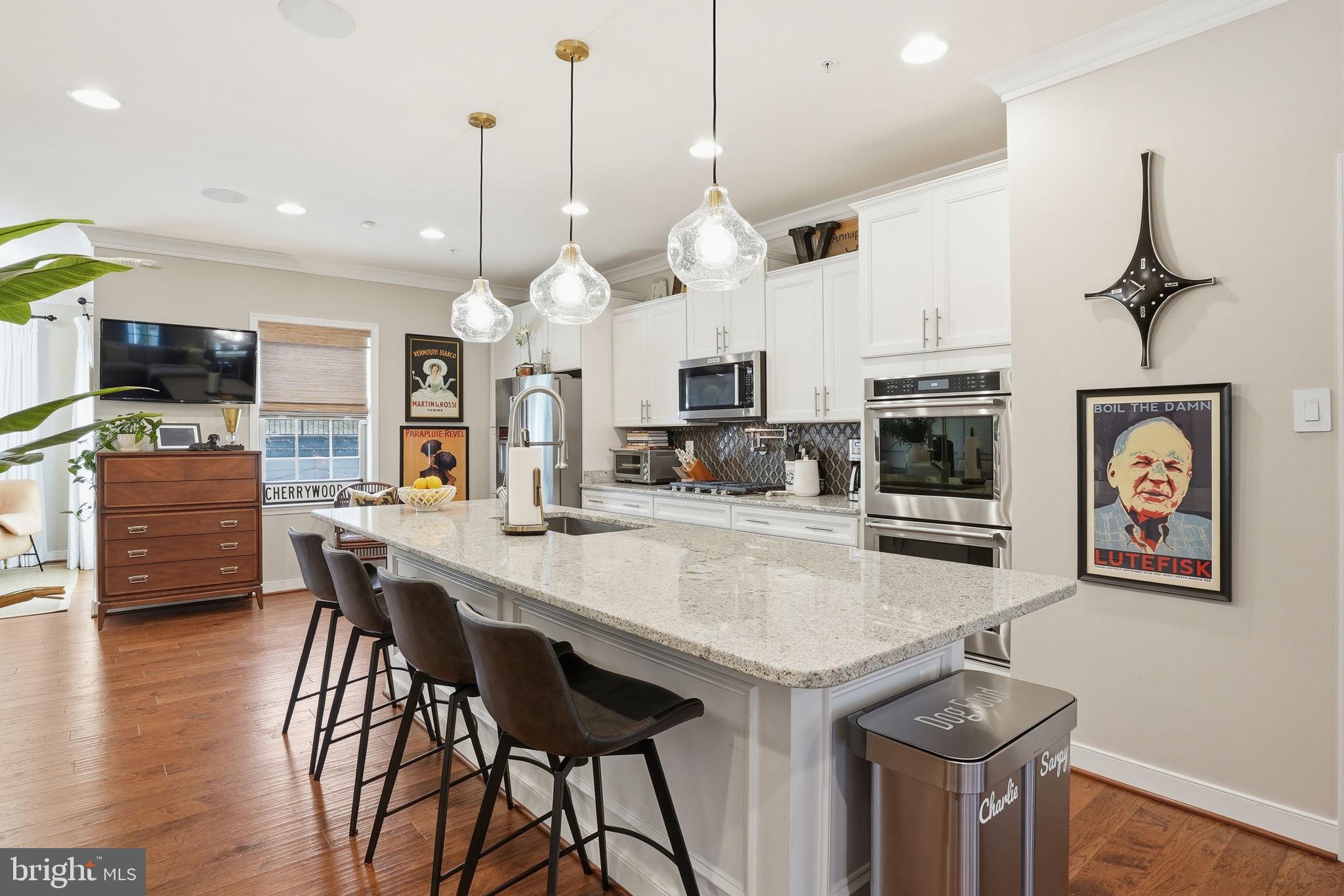 126 Admirals Ridge Drive Arnold, MD 21012 - Photo 4 of 58 a large kitchen with stainless steel appliances granite countertop a stove a sink a dining table and chairs with wooden floor
