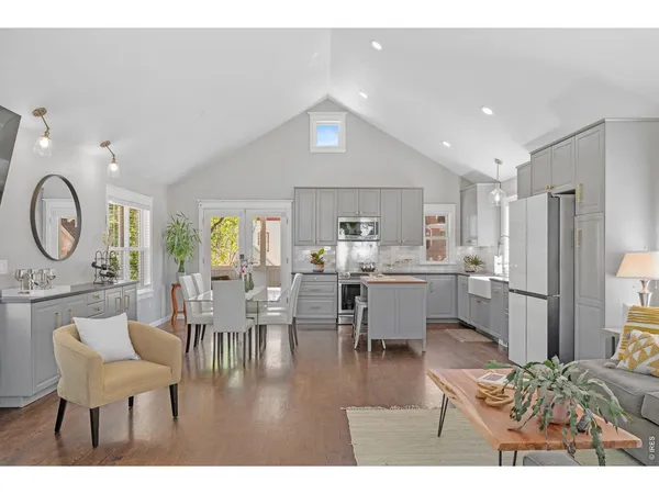 a living room with stainless steel appliances kitchen island granite countertop furniture and a large window