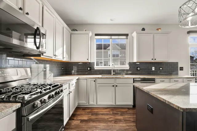 a kitchen with stainless steel appliances a sink stove and cabinets