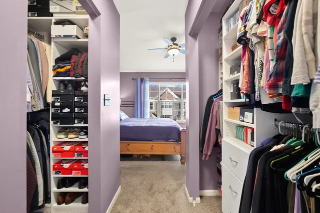 a view of walk in closet with clothes and shoes