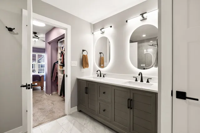 a en suite bathroom with double vanity sinks and a mirror
