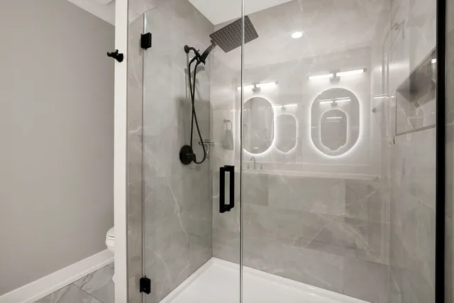 a bathroom with a shower a mirror and tub