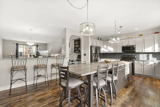 a view of a dining room and kitchen with furniture wooden floor and a chandelier