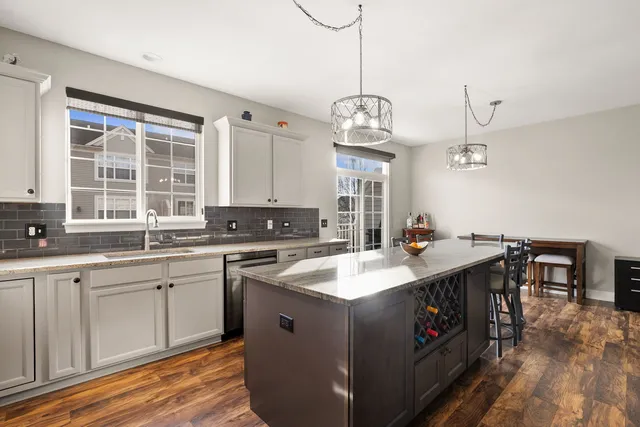 a kitchen with stainless steel appliances granite countertop a sink a stove and a wooden floors