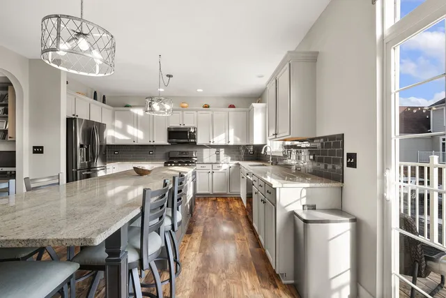 a kitchen with stainless steel appliances granite countertop a stove refrigerator and cabinets